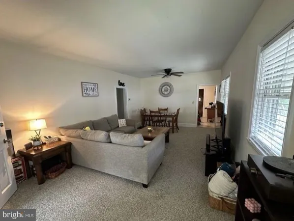 a living room with furniture a window and a lamp