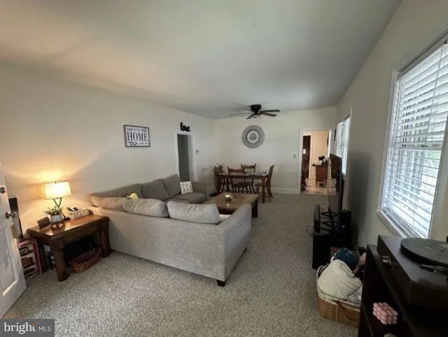 a living room with furniture a window and a lamp