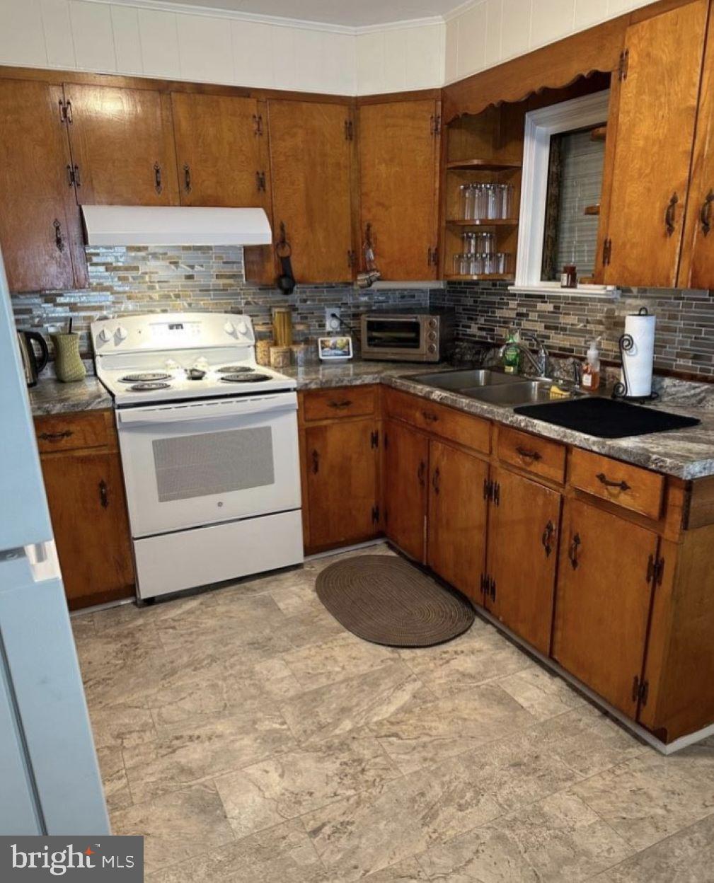 409 Myrtle Street Crisfield, MD 21817 - Photo 10 of 19 a kitchen with stainless steel appliances granite countertop a stove a sink and a microwave