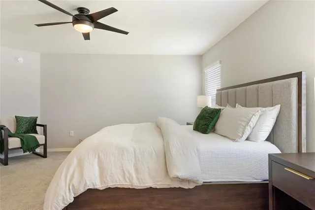 a bedroom with a bed and a flat tv screen on dresser