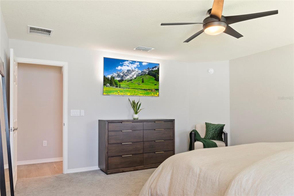 1204 Mezzavalle Way Auburndale, FL 33823 - Photo 22 of 42 a bedroom with a bed and a flat tv screen on dresser