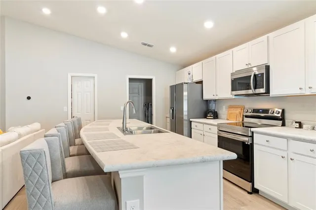 a kitchen with stainless steel appliances kitchen island granite countertop a sink and cabinets