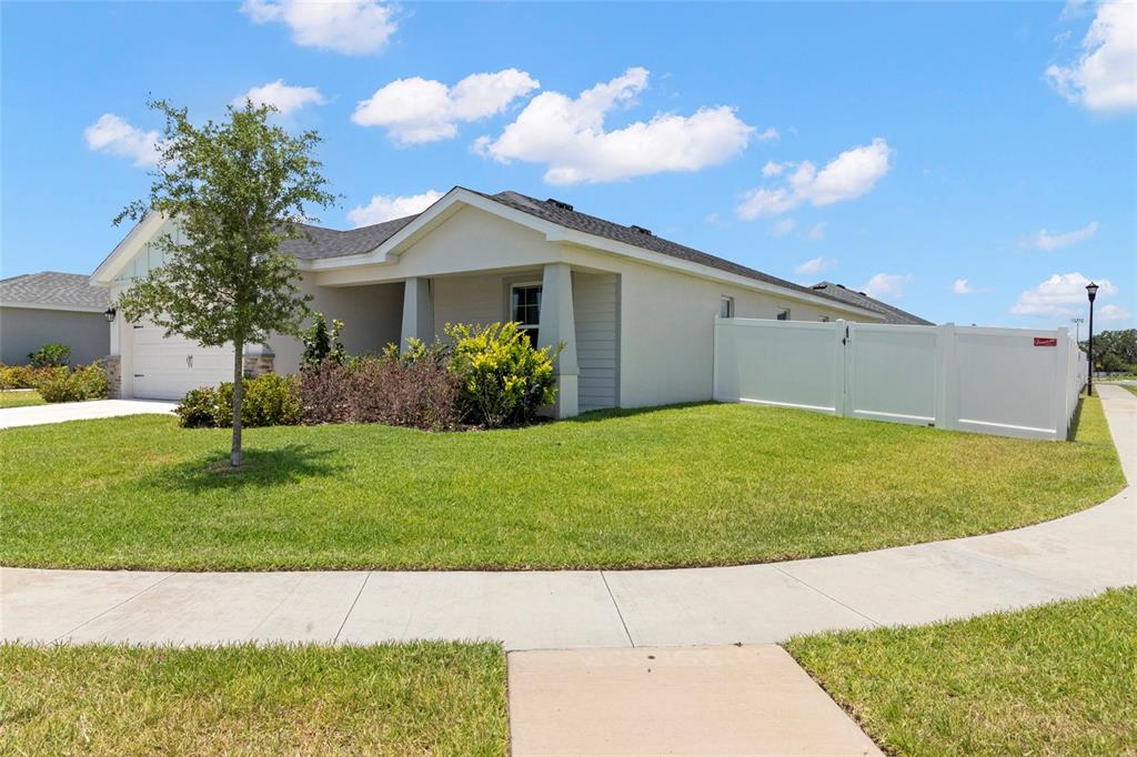 1204 Mezzavalle Way Auburndale, FL 33823 - Photo 6 of 42 a front view of a house with a garden and yard