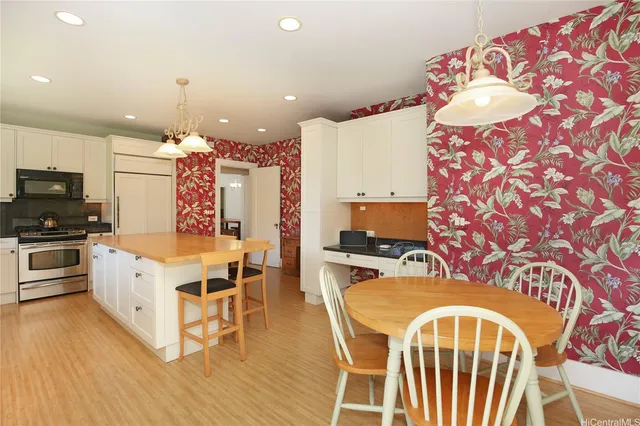 a kitchen that has a lot of white cabinets and wooden floor