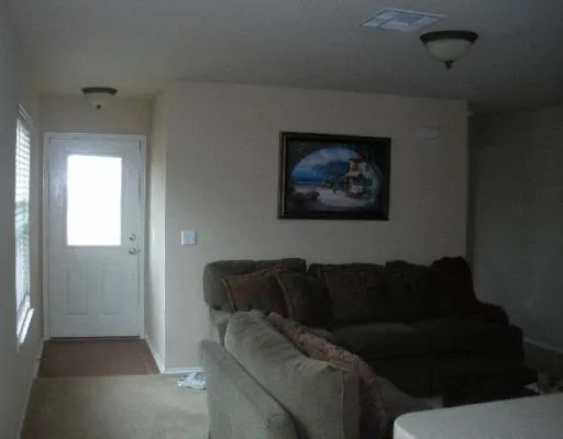 a living room with furniture and a painting on the wall