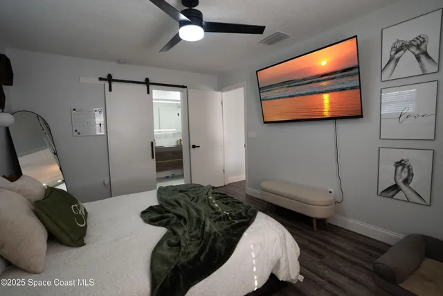 a bedroom with a bed and a flat screen tv