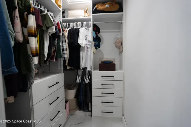 walk in closet with clothes and shoes