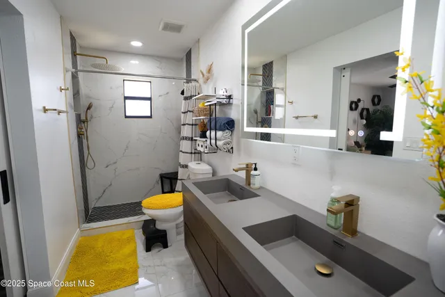 a bathroom with a sink a toilet and shower