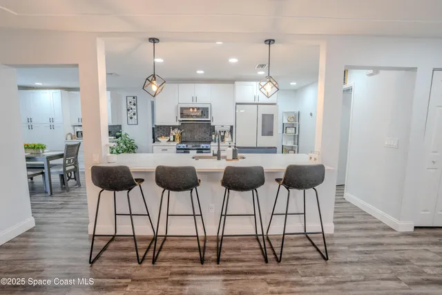 a kitchen with cabinets table and chairs