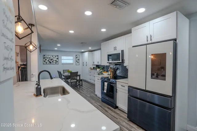 a kitchen with stainless steel appliances a refrigerator sink and microwave