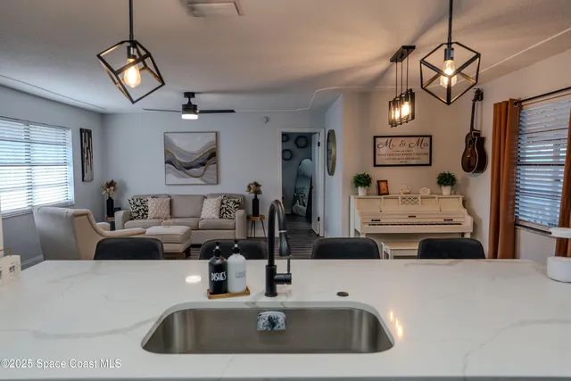 a kitchen with a sink a stove and a chandelier