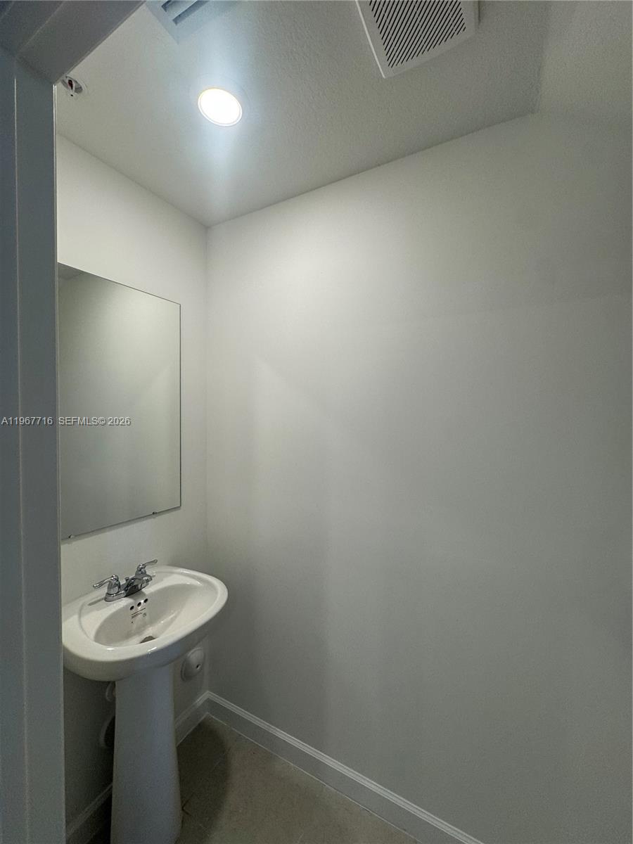12420 Southwest 248th Street, Unit 4 Homestead, FL 33032 - Photo 13 of 20 a bathroom with a sink a mirror and a toilet