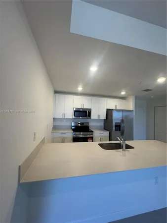 a large kitchen with a sink and a stove top oven