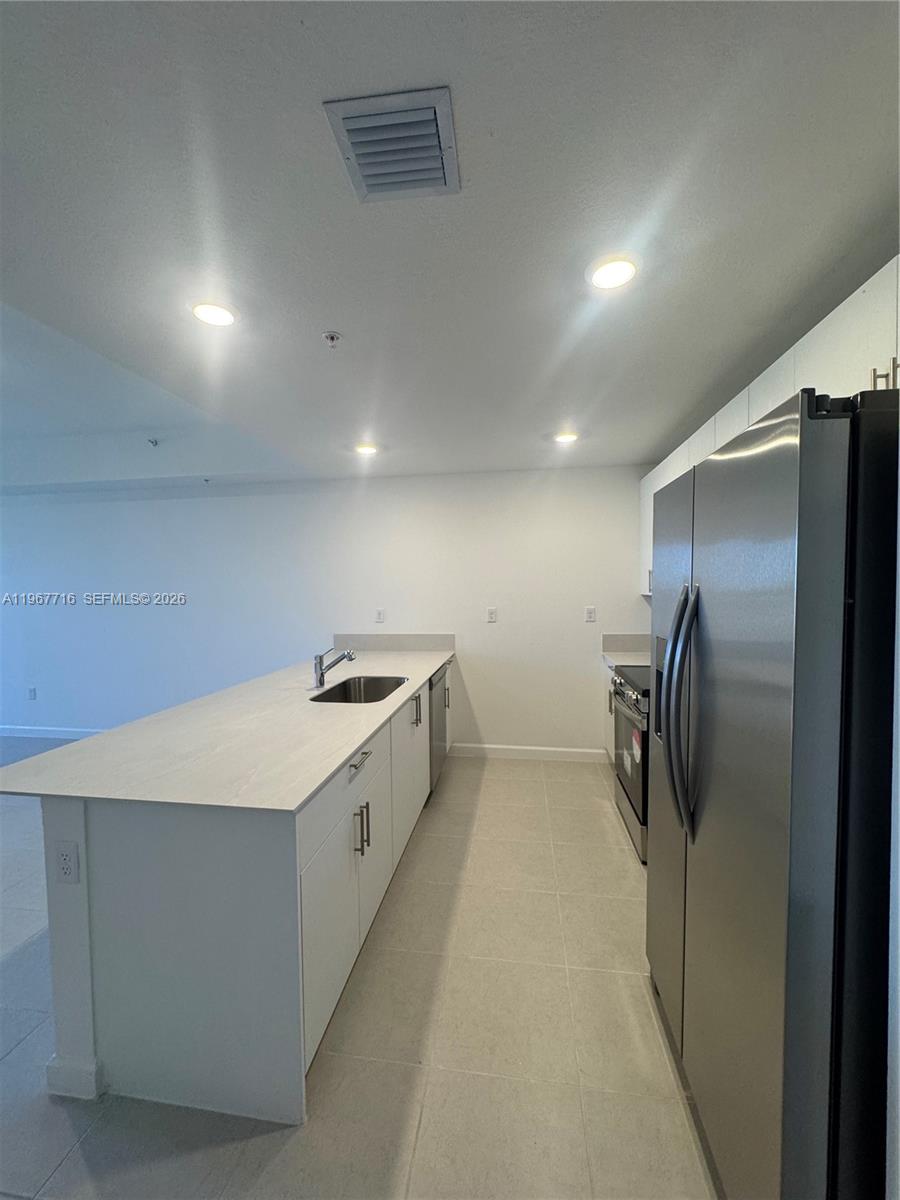 12420 Southwest 248th Street, Unit 4 Homestead, FL 33032 - Photo 8 of 20 a kitchen with refrigerator and car parked