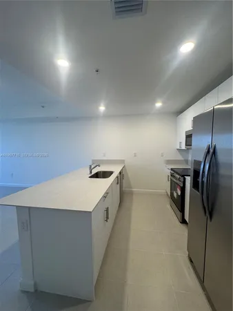 a kitchen with refrigerator and car parked