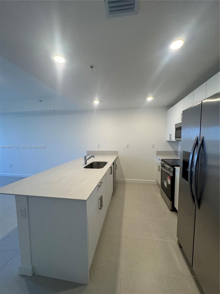 12420 Southwest 248th Street, Unit 4 Homestead, FL 33032 - Photo 9 of 20 a kitchen with refrigerator and car parked
