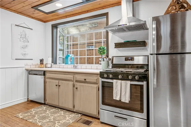 a kitchen with stainless steel appliances granite countertop a stove a refrigerator and a sink