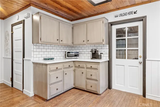 a kitchen with white cabinets and wooden floors