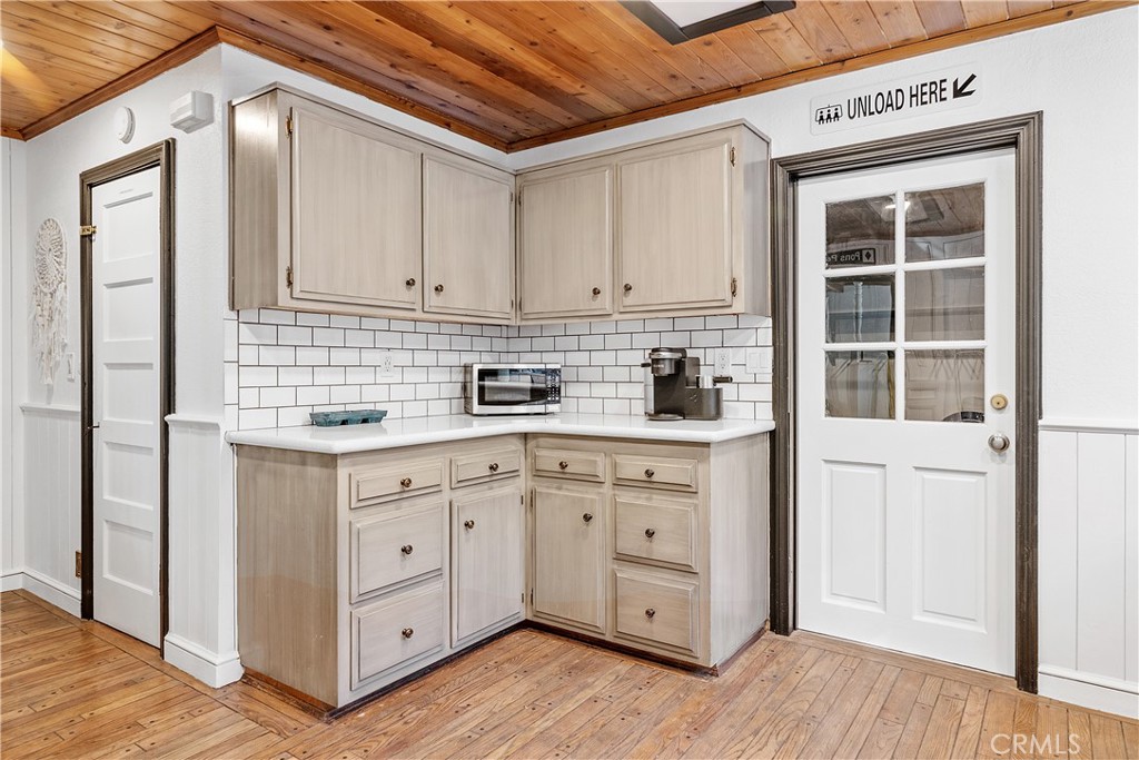 660 Barrett Way Big Bear City, CA 92314 - Photo 13 of 32 a kitchen with white cabinets and wooden floors