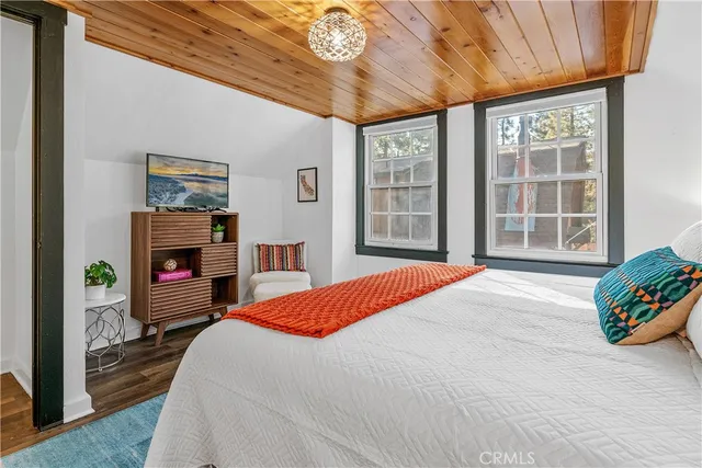 a bed sitting in a bedroom next to a larger window