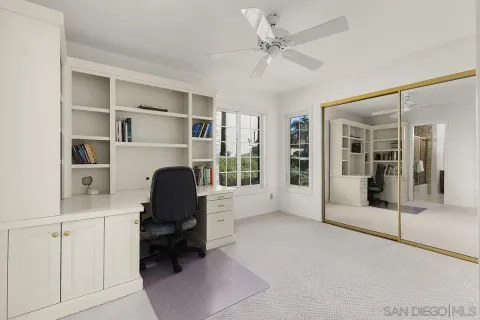 a view of a garden with a lot of flower plants and wooden fence