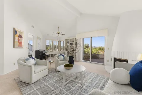 a living room with fireplace furniture and a large window