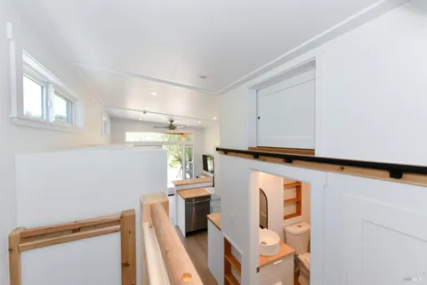 a view of a kitchen with fridge and wooden floor