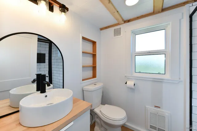 a bathroom with a sink a toilet and a mirror