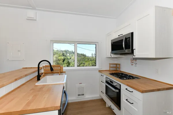 a kitchen with a stove a sink and a microwave