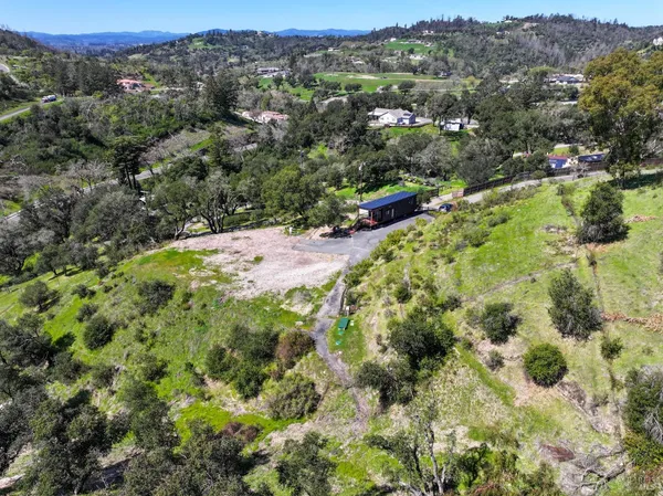 an aerial view of residential houses with outdoor space and trees