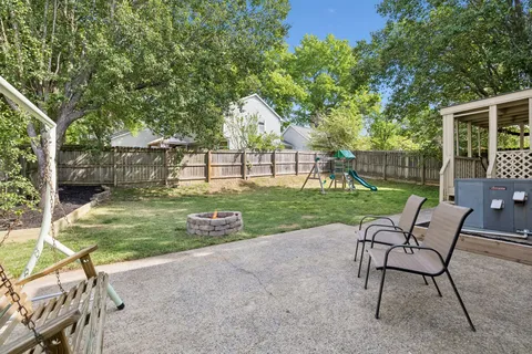 a view of a chair and table in backyard of the house