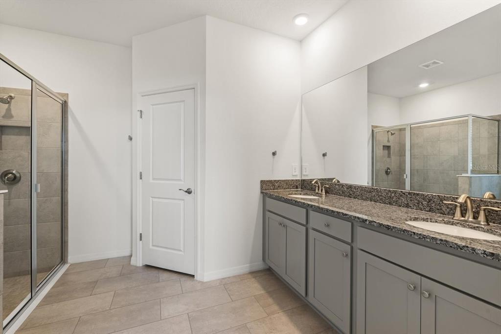 17738 Pastureland Avenue Lakewood Ranch, FL 34211 - Photo 17 of 50 a bathroom with a granite countertop sink mirror and double