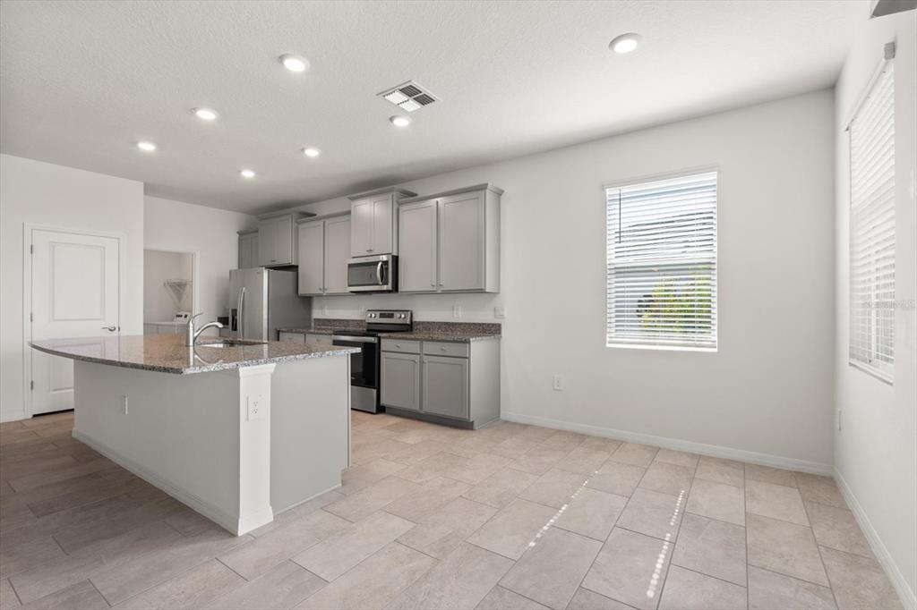 17738 Pastureland Avenue Lakewood Ranch, FL 34211 - Photo 8 of 50 a kitchen with white cabinets and window