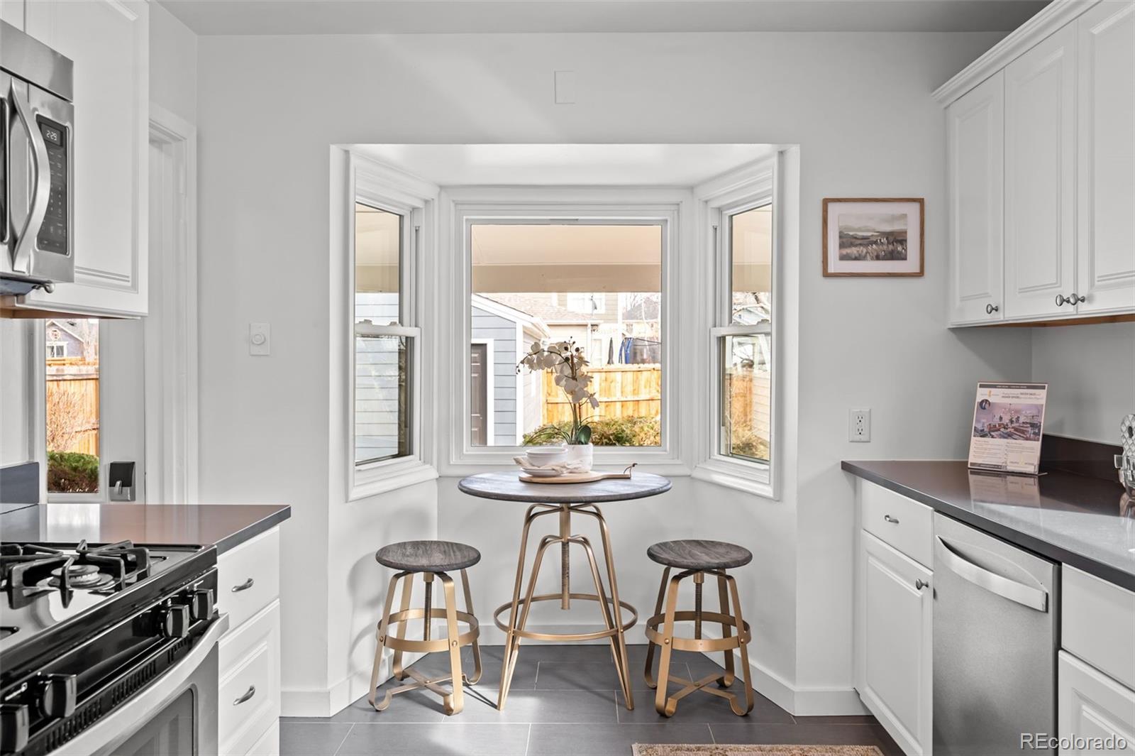 2344 South Lafayette Street Denver, CO 80210 - Photo 11 of 32 a kitchen with stainless steel appliances granite countertop a stove a sink and a refrigerator