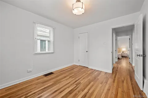 a view of a room with wooden floor and a window