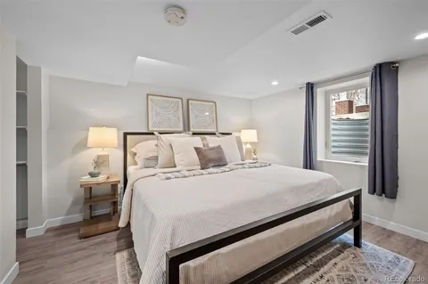 a bedroom with a bed and wooden floor