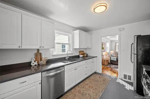 a kitchen with granite countertop a sink stainless steel appliances and cabinets