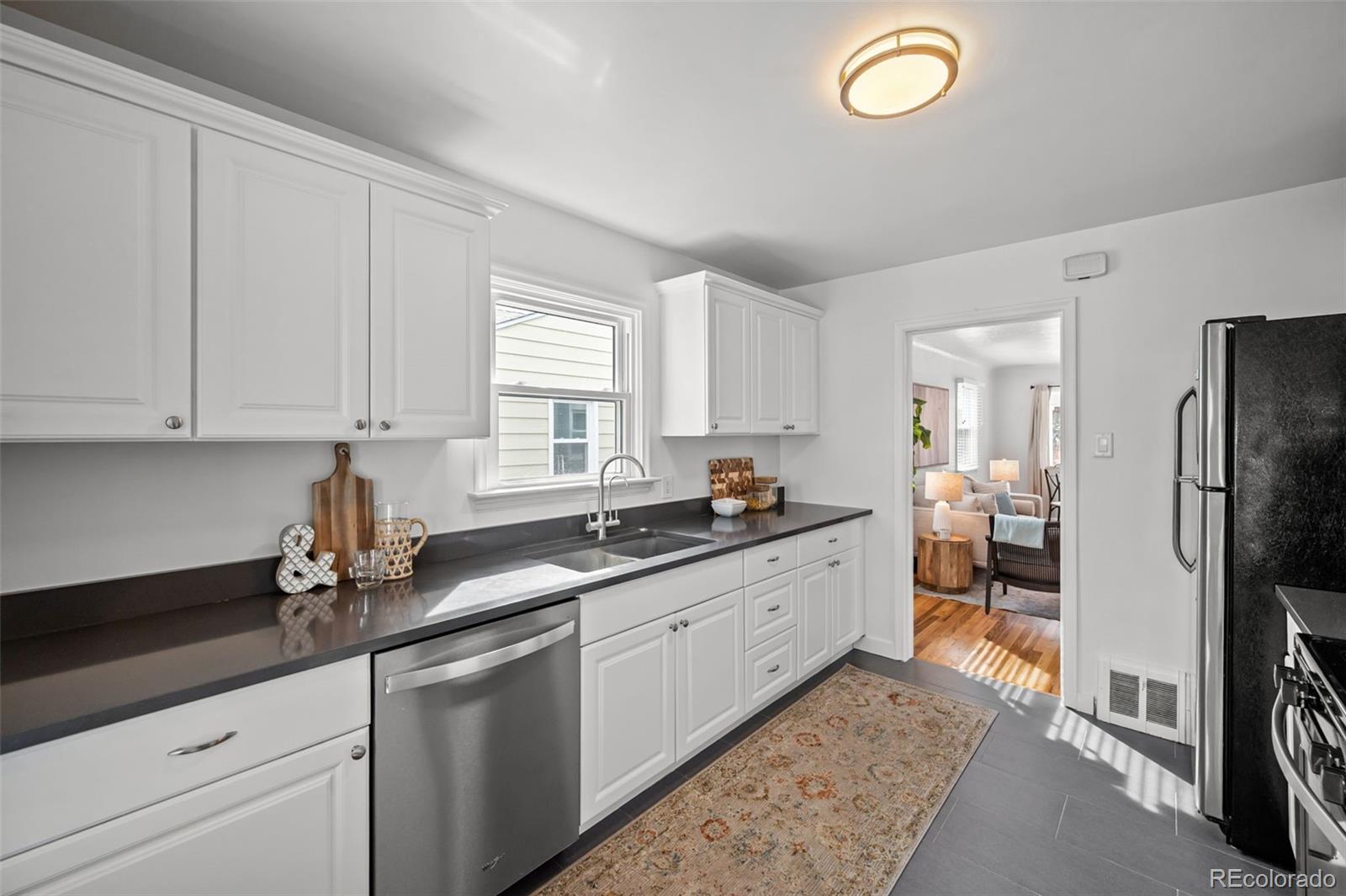 2344 South Lafayette Street Denver, CO 80210 - Photo 10 of 32 a kitchen with granite countertop a sink stainless steel appliances and cabinets