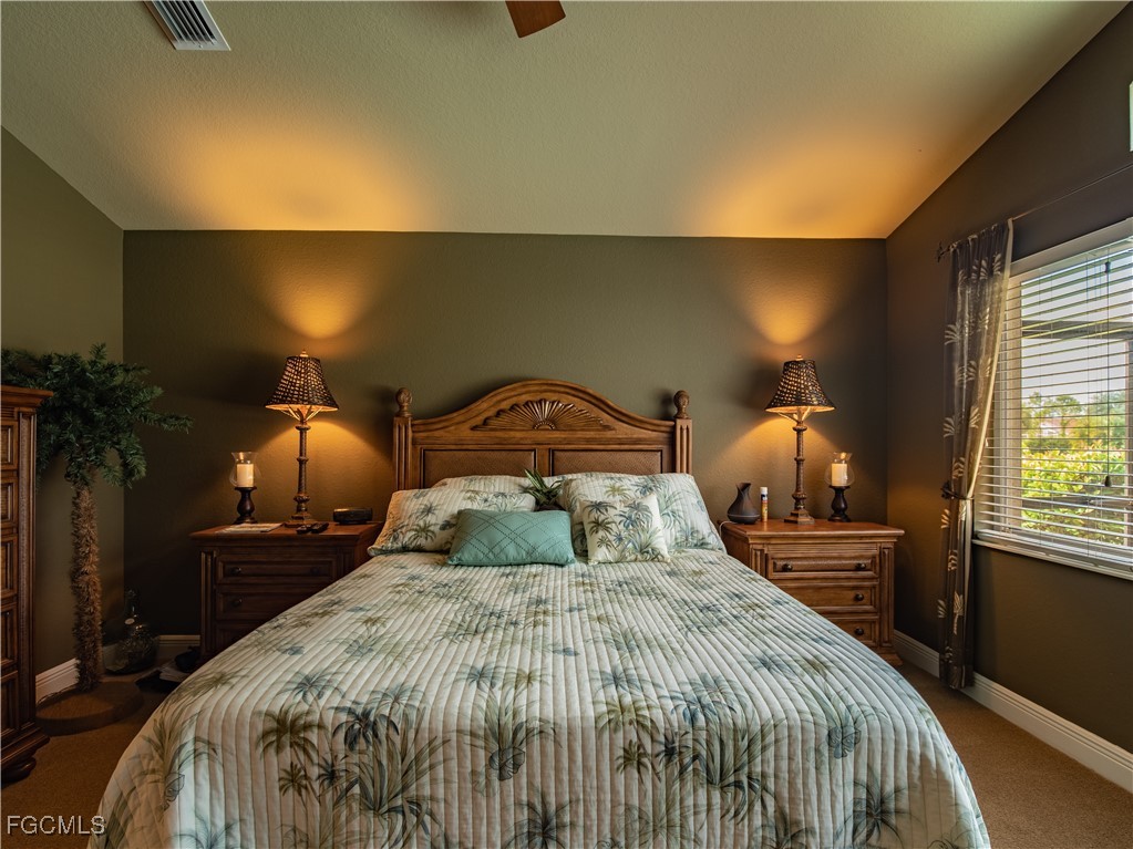 20311 Rookery Drive Estero, FL 33928 - Photo 20 of 29 a bedroom with a bed and lamp with window