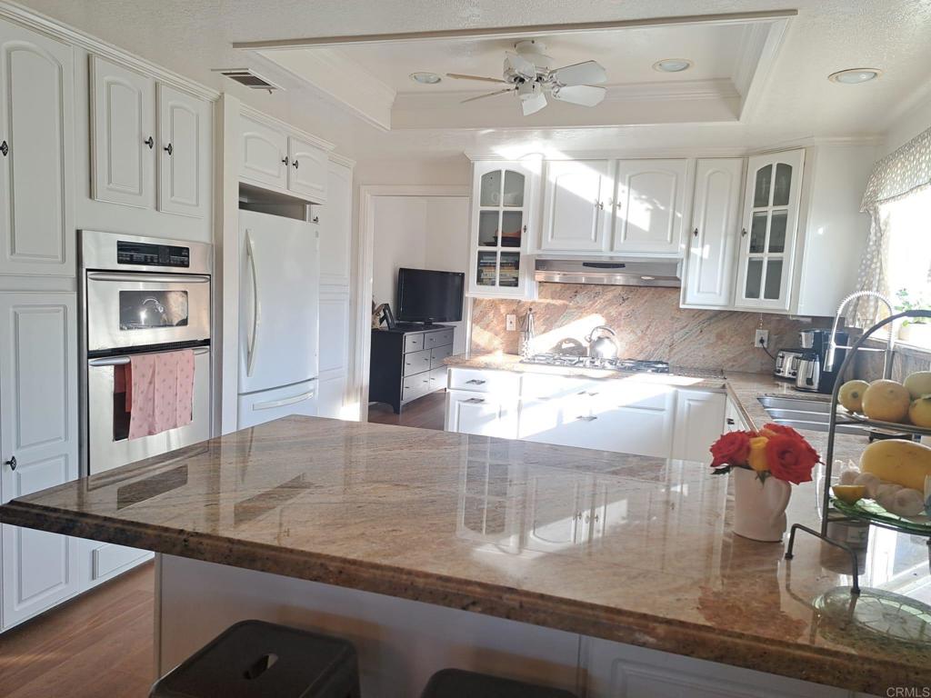 40752 Via De La Roca Fallbrook, CA 92028 - Photo 4 of 37 a kitchen with stainless steel appliances granite countertop a sink and a refrigerator