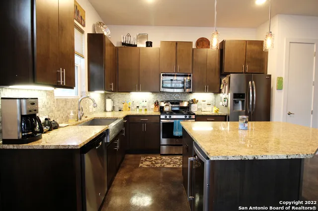 a kitchen with stainless steel appliances granite countertop a sink stove and refrigerator