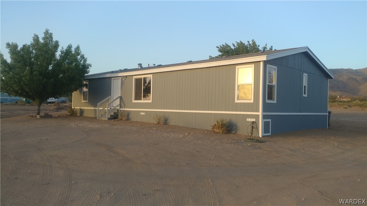 a view of a house with backyard and a tree