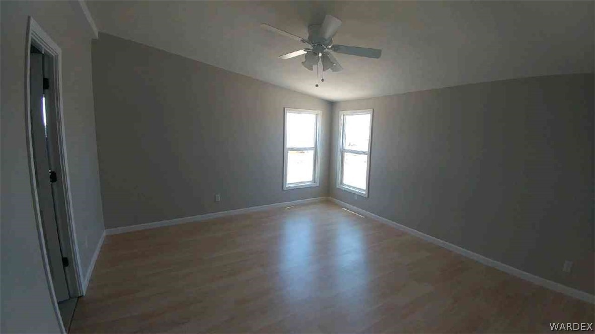 3634 Bibo Road Golden Valley, AZ 86413 - Photo 11 of 44 an empty room with wooden floor and windows