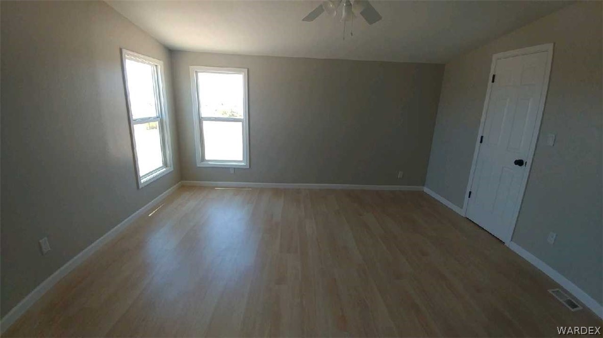 3634 Bibo Road Golden Valley, AZ 86413 - Photo 28 of 44 an empty room with wooden floor and windows