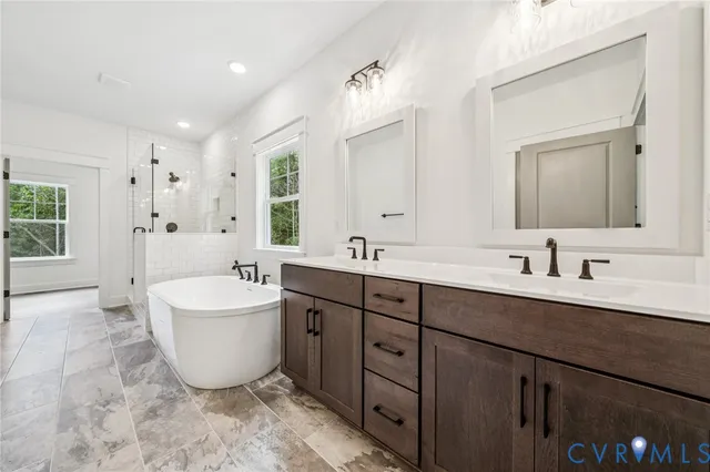 a spacious bathroom with a double vanity sink mirror and bathtub