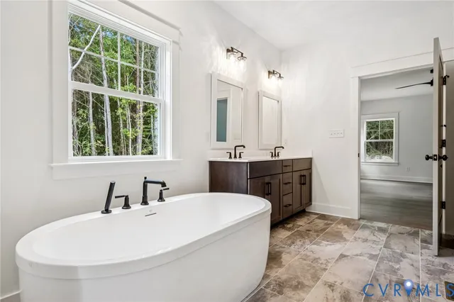 a bathroom with a sink a tub and a mirror