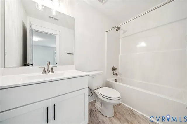 a bathroom with a sink toilet vanity and shower