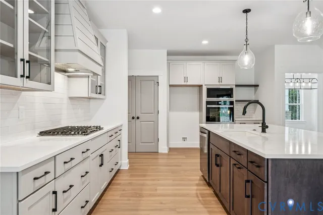 a kitchen with stainless steel appliances a sink stove and cabinets