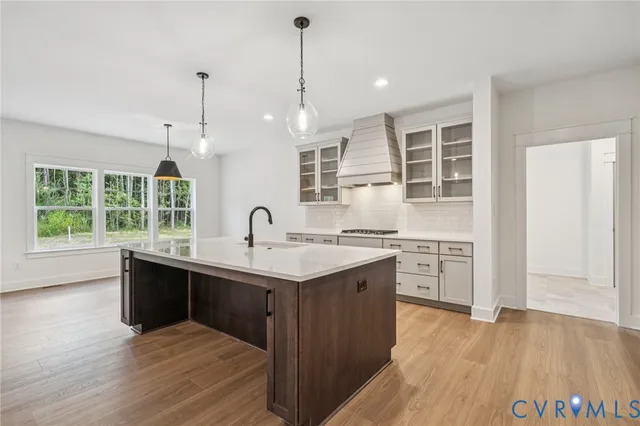 a kitchen with stainless steel appliances granite countertop a sink a stove and a wooden floors