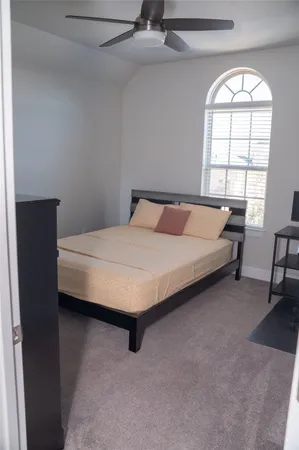 a bedroom with a bed and a window